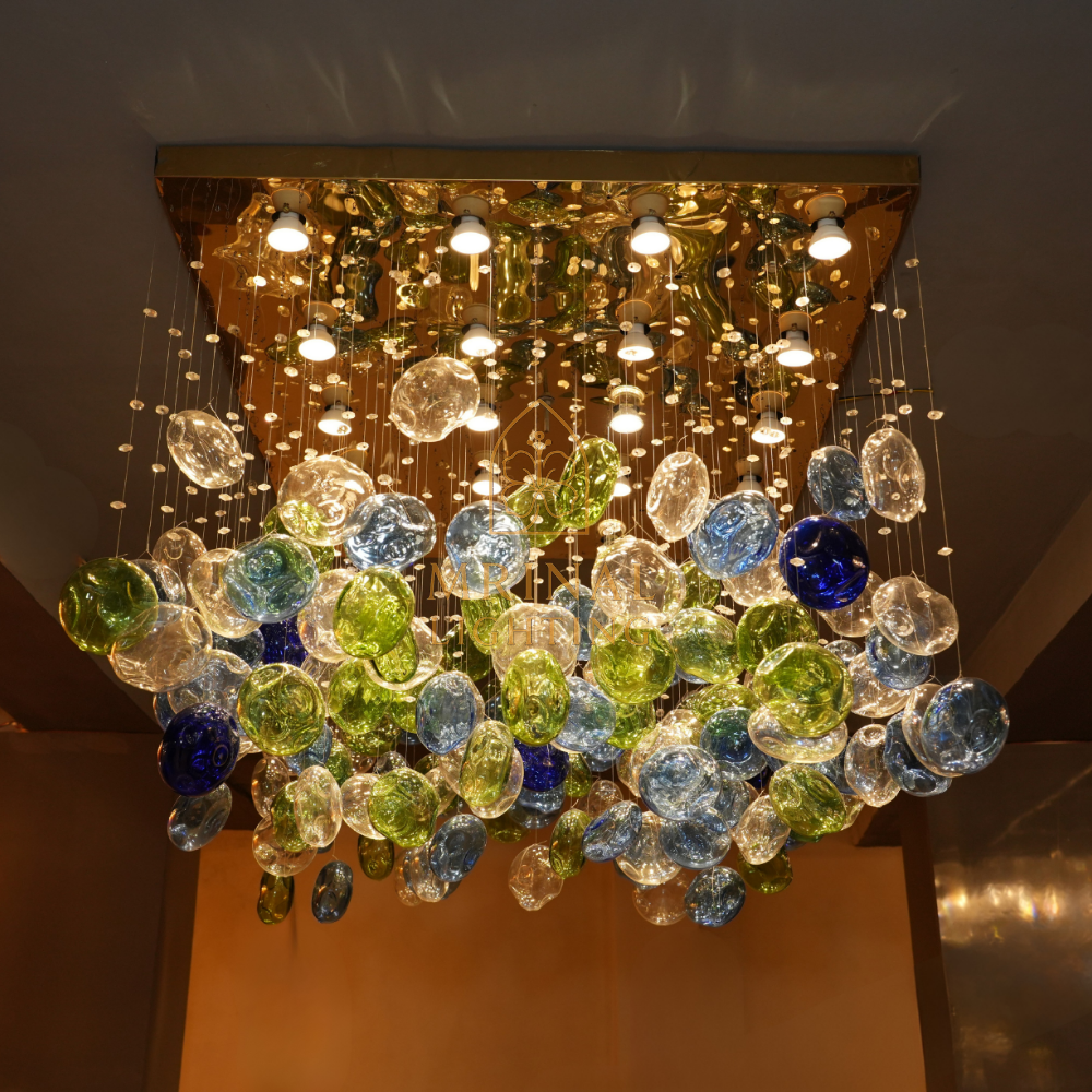 Artistic banquet chandelier with clear and coloured bloom glass – handcrafted by Mrinal Lighting